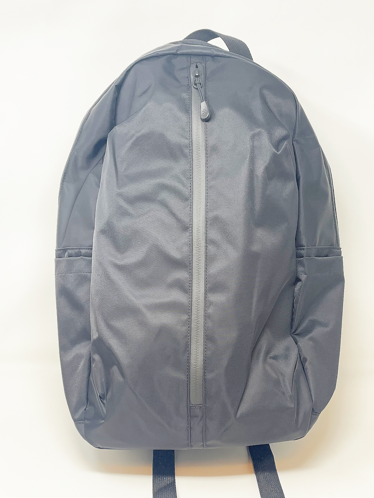 縦方向に開くファスナーが特徴的。表面のテロテロした質感は好みの分かれるところかもしれません。