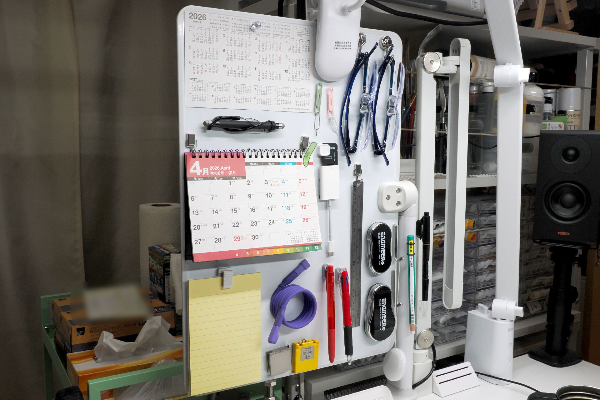 いろいろなモノをマグネット吸着させているボードはサンコー「360度自由自在クランプ式ホワイトボード」の「大」サイズ。直販価格6,680円。デスク左側にセットしている。