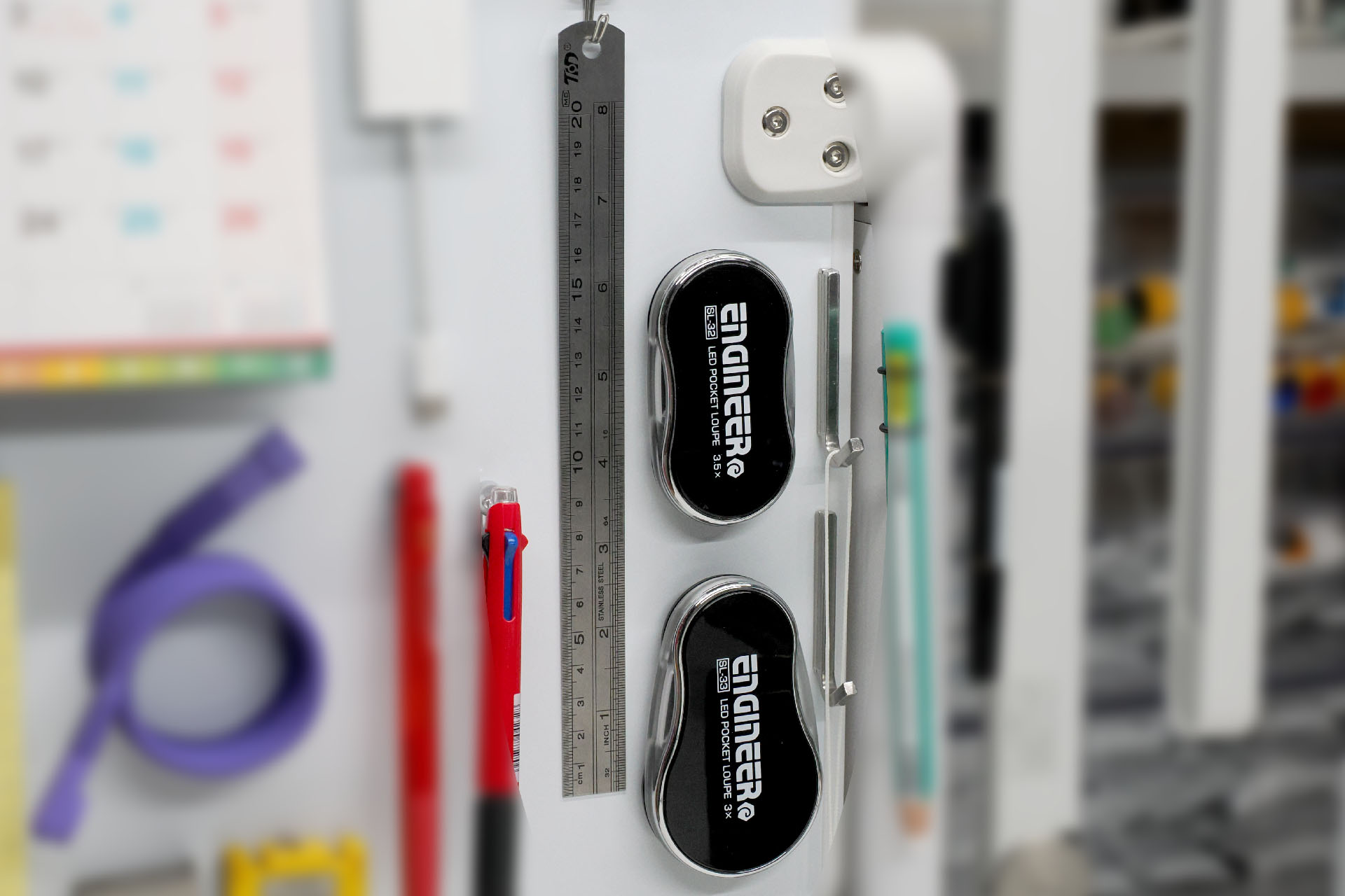 ルーペや定規も「空中収納」。上記の使用頻度が低いペン類もそうだが、使用頻度が低くても週に何度か使うようなものは、すぐ手に取れるとイイ。引き出しから取り出して……という少々の手間がなくなり、即使えるので、時短になりかつストレス減にもなって快適。