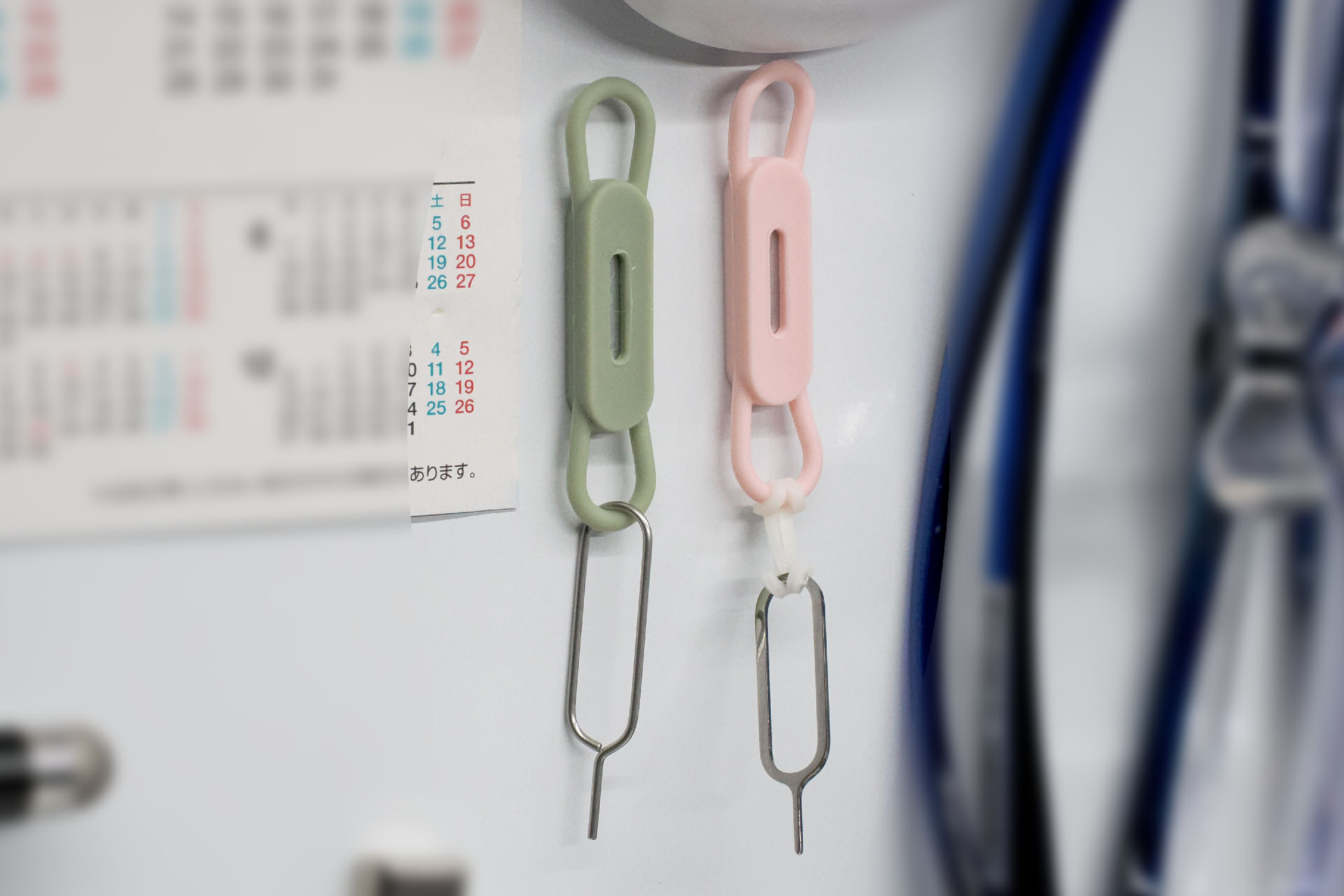 たまーに使うSIMピンも「空中収納」。後述の市販グッズを使っているが、SIMピンを探す手間がなくなり、手が滑って小さなSIMピンを落とすことも軽減できる。