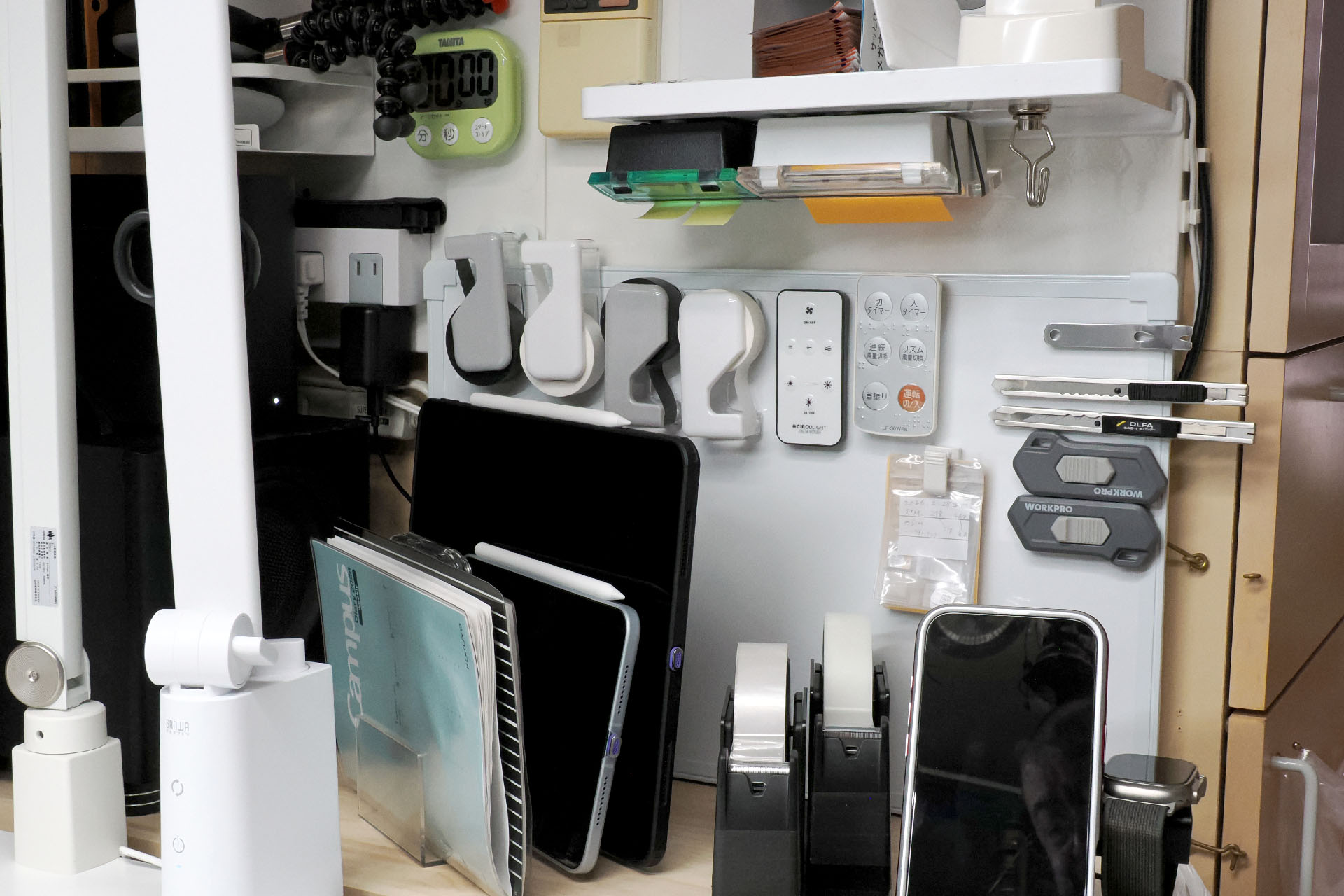 デスク右側下方は、着座しつつぎりぎり手が届く位置。よく使うリモコンやツールなどを「空中収納」している。カッターナイフやマスキングテープは毎日のように使うが、「空中収納」しておくとデスクが散らからずに好都合＆実用的なのだ。予備のSIMなんかも「空中収納」しておくと「あれぇ?予備SIMどこに片づけたっけ?？」みたいなコトがなくなる。