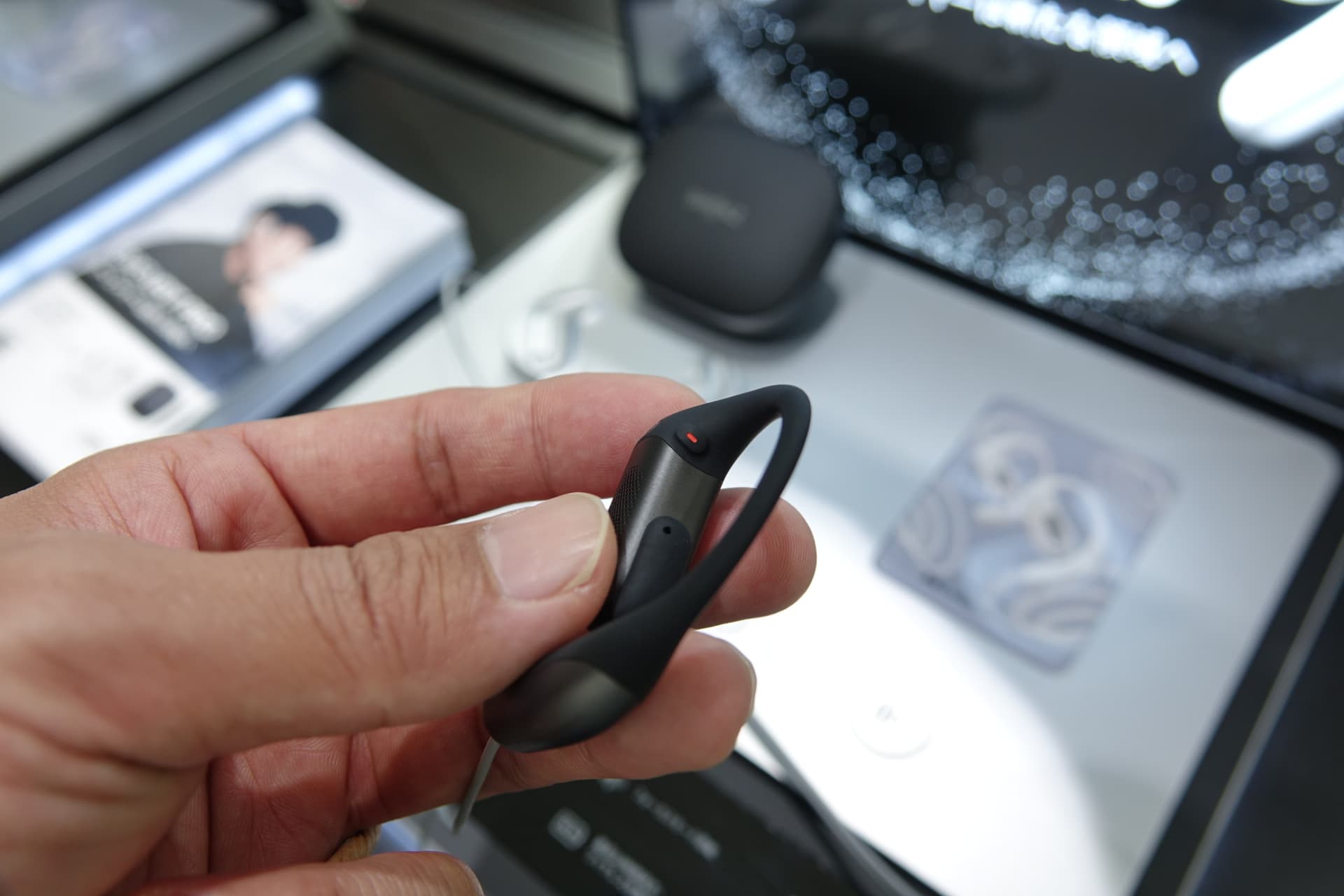 イヤホンの物理ボタン。フォーカスモードの切り替えや再生／停止、音量調整、曲送りなどが割り当てられる。割り当ては、スマートフォンアプリから切り替え可能。担当者によると、汗や髪などが触れると誤作動の可能性があるため、タッチセンサーではなく物理ボタンを採用しているという