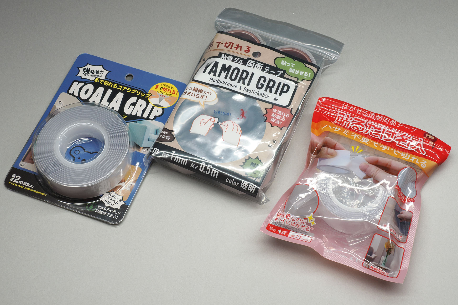 手で切れるタイプの魔法のテープ各種。以前はAmazonあたりでしか買えなかったが、最近では100均やホームセンターでもよく見かけるようになった。厚さや粘着力のバリエーションも増えつつあるようだ。ハサミなどで切る必要があるタイプは、ハサミでも切りにくく、切ったときにハサミに粘着剤が付着したりして、ちょっと面倒。手で切れるタイプは、断面がハサミで切ったときほどキレイにならないが、道具要らずで使えてスゲく便利だ。またこういう粘着剤の場合、断面が汚くても「貼った粘着剤が見えなくなることが多い」ので実用上大した問題にはならない。また手で切れるタイプも、もちろんハサミなどで切ることができる。ただし、その性質上、透明テープ内部に白いメッシュ繊維が見える。