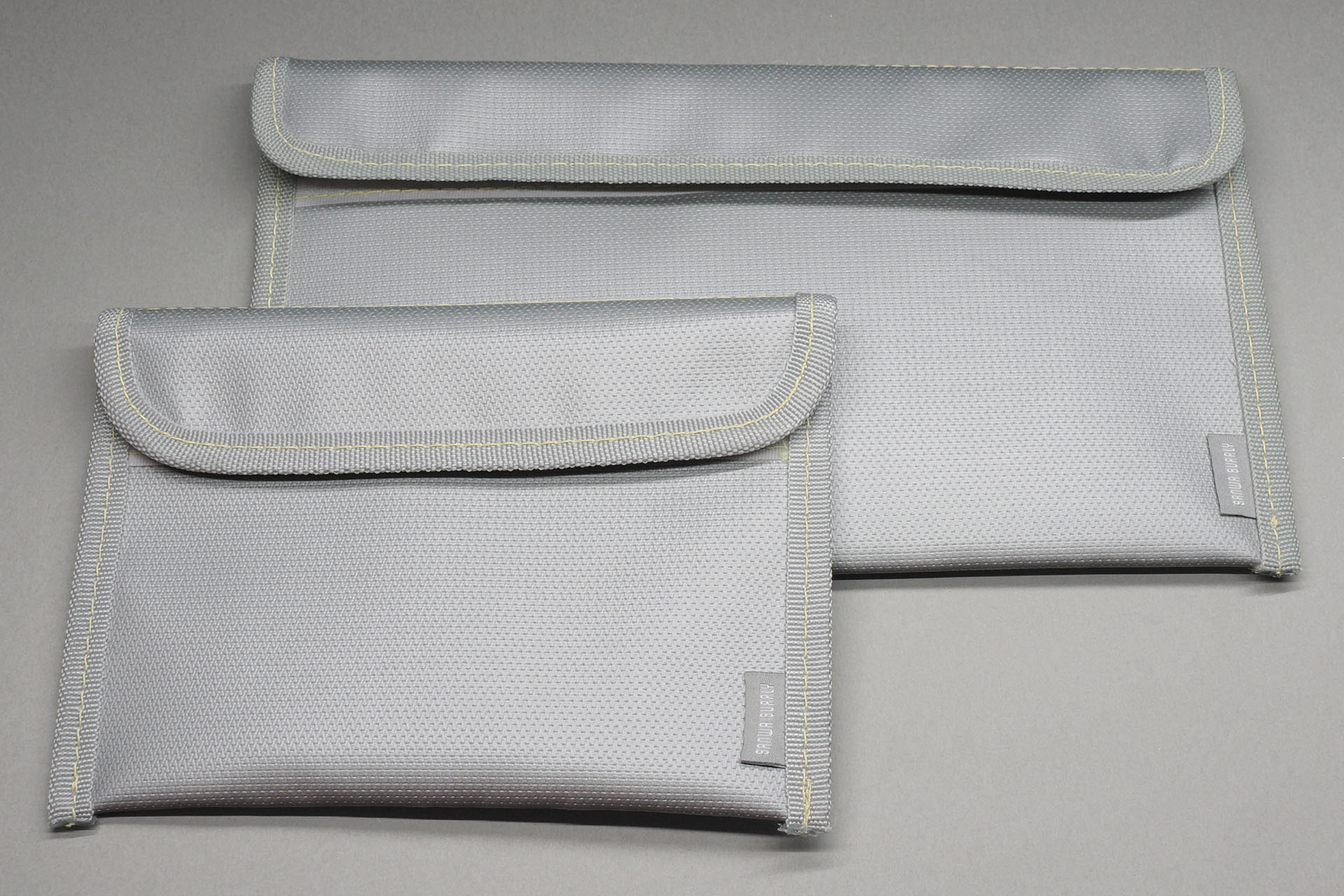 サンワサプライの「モバイルバッテリーケース 難燃性ケース」。表面は柔らかめの樹脂素材。ポーチのような感じ。