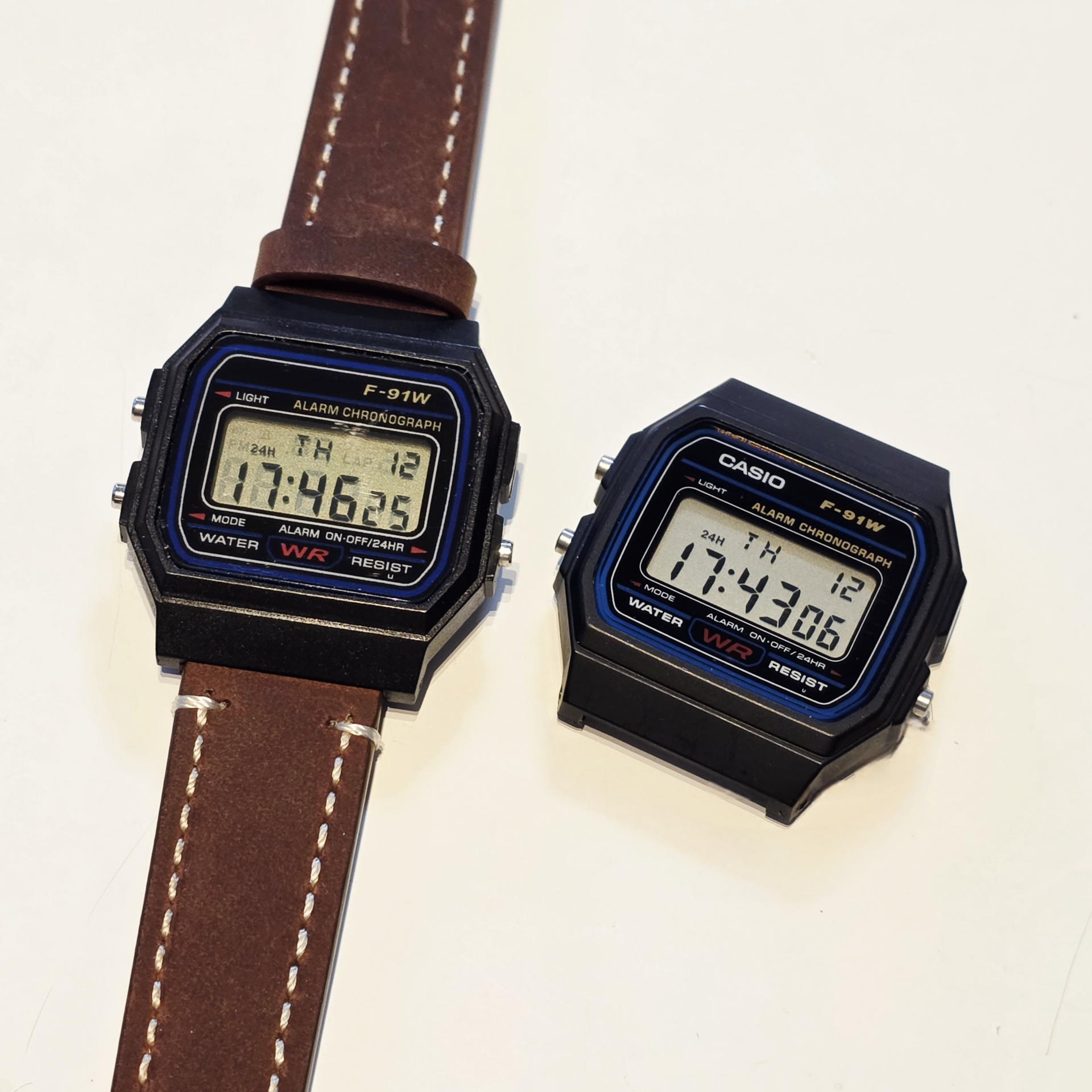 純正F-91W（左）と、本革を纏ったオマージュモデル（右）。ロゴが無い分、ベルトの個性が際立つ