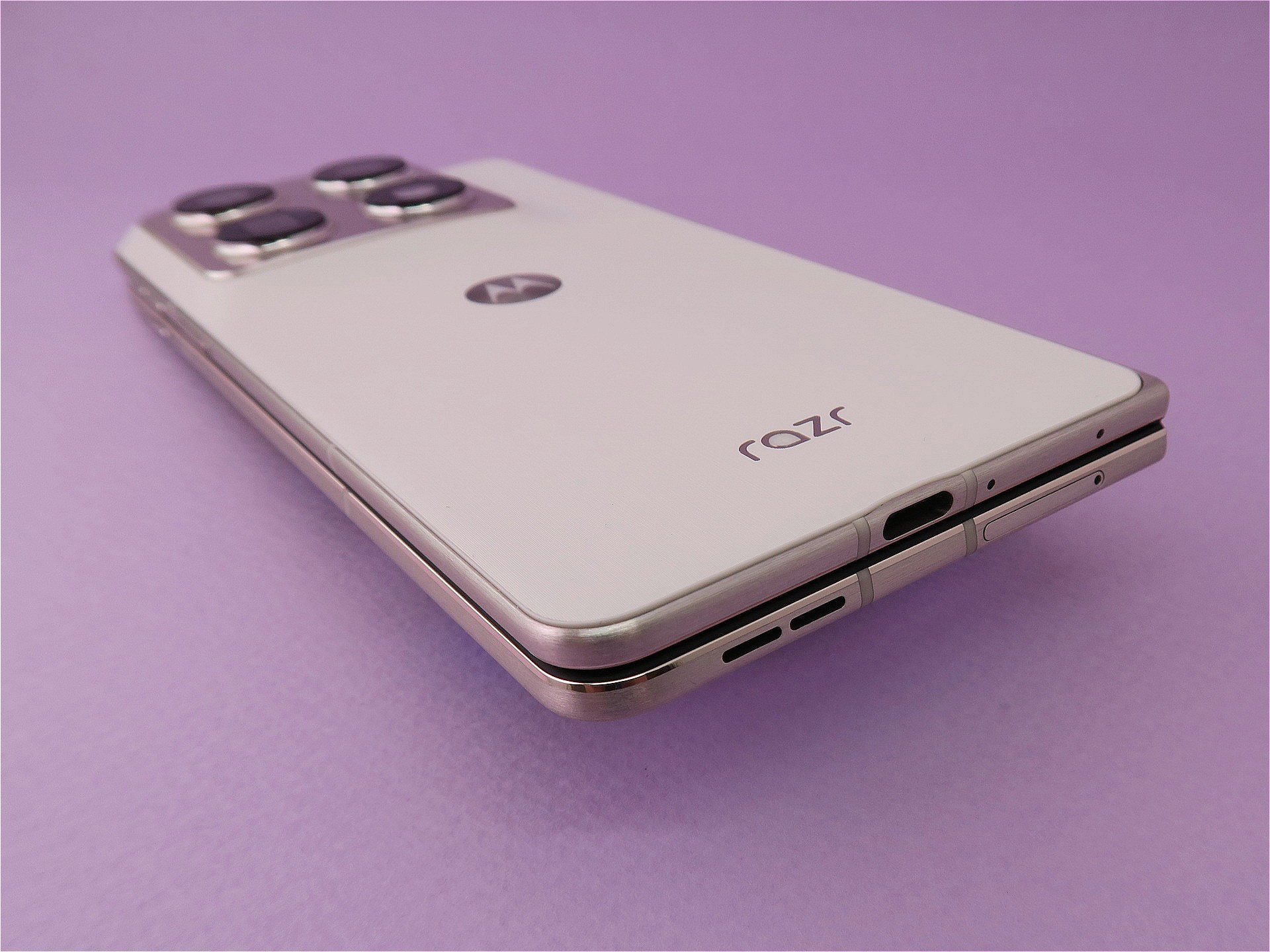 本体を閉じた状態の下部。右筐体（上側）の下部にはUSB Type-C外部接続端子を備える。左筐体（下側）のヒンジよりの部分にはピンで取り出すタイプのSIMカードスロットを備える