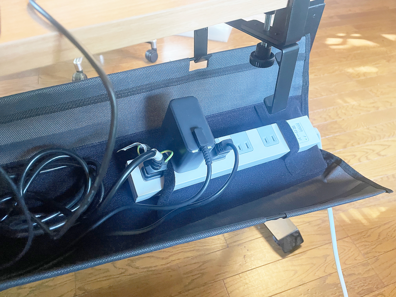 底面に面ファスナーで電源タップを固定できます。また片側を開くことができるのでメンテナンスも簡単です。