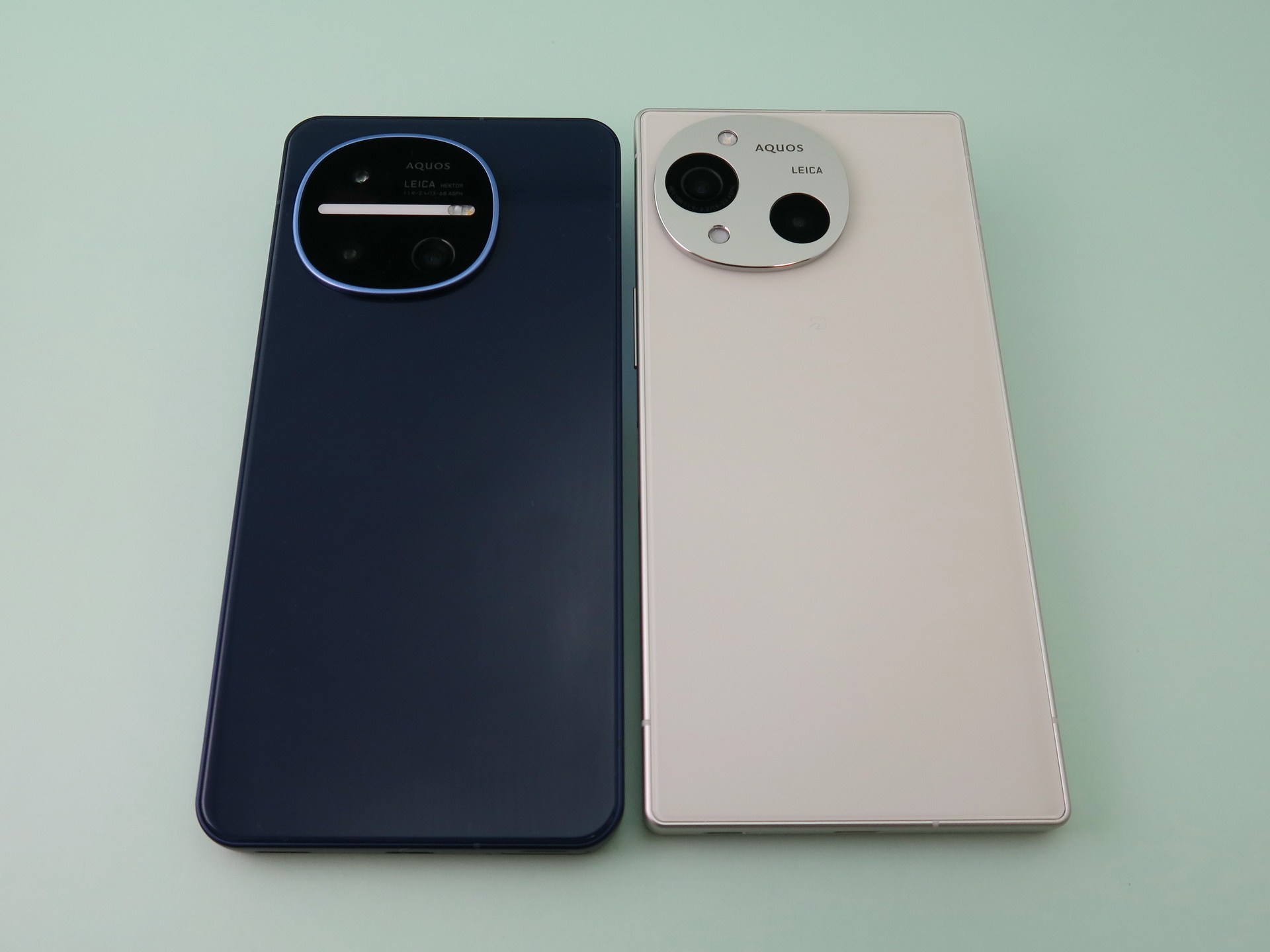 「AQUOS R11」（左）と「AQUOS R10」（右）の背面。自由曲線で描かれたカメラ部は、やや形状が変更された印象で、中心にアカリウムのLEDが内蔵される