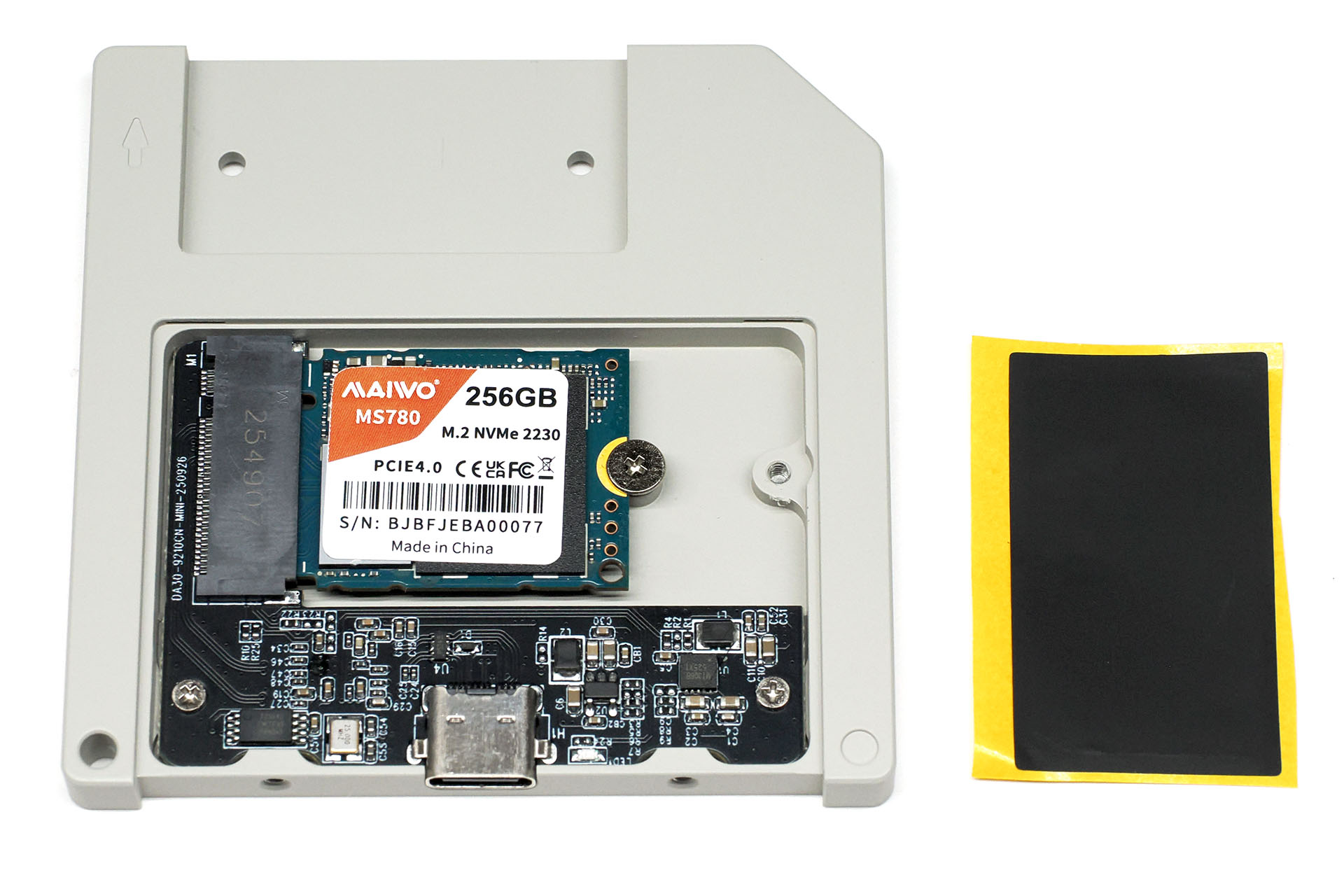 SSDを入れた様子。M.2 2230/2242 NVMe SSD（B+M Key/M Key）に対応する。SSDはスロットに対して水平後方に押し込むようにセットする（傾けて挿し入れるタイプではない）。SSD固定ネジは「＋」で付属L字レンチで回せる。SSD表面に前出のSSD放熱シートを貼ってフタを閉じる。