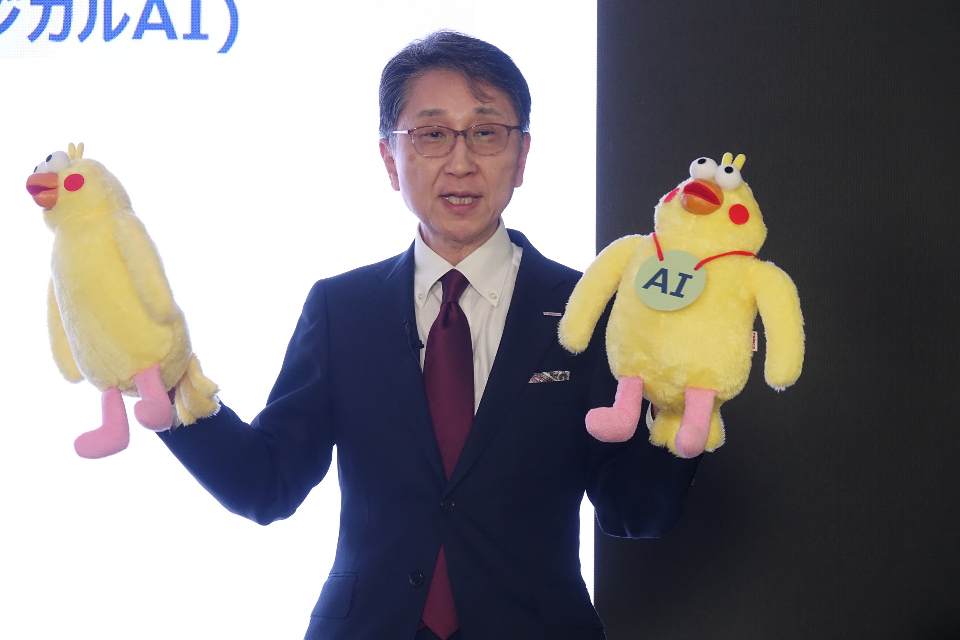 同じく金井俊夫副社長。ポインコのぬいぐるみを手にロボットにおけるAIの有無を説明中