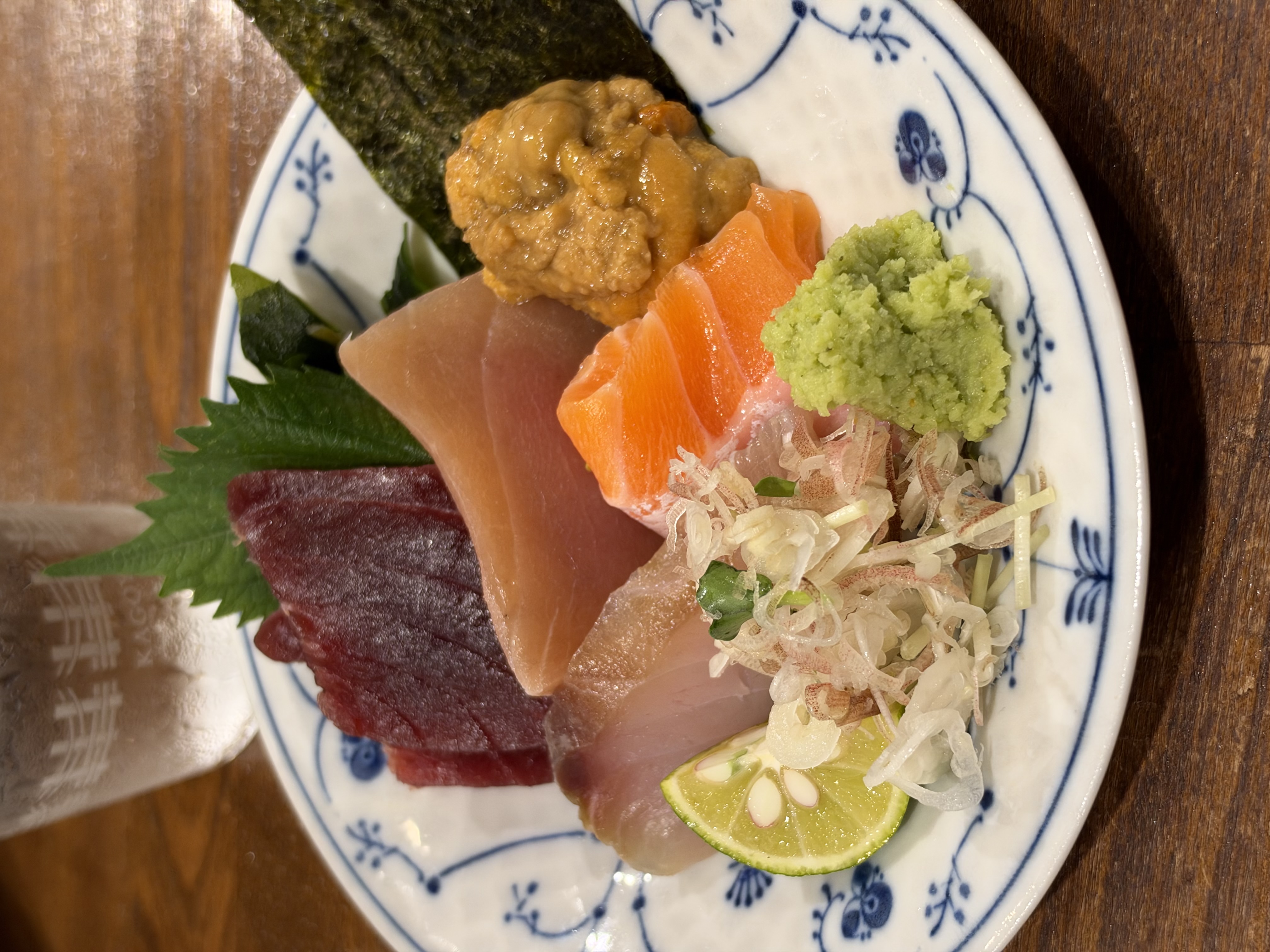 卓上に並んだ新鮮な刺身の盛り合わせをクローズアップ。魚の瑞々しいツヤ感から薬味の細かなディテールに至るまでシズル感たっぷりに描写されており、近接撮影におけるカメラの優秀さが際立つカットになった。