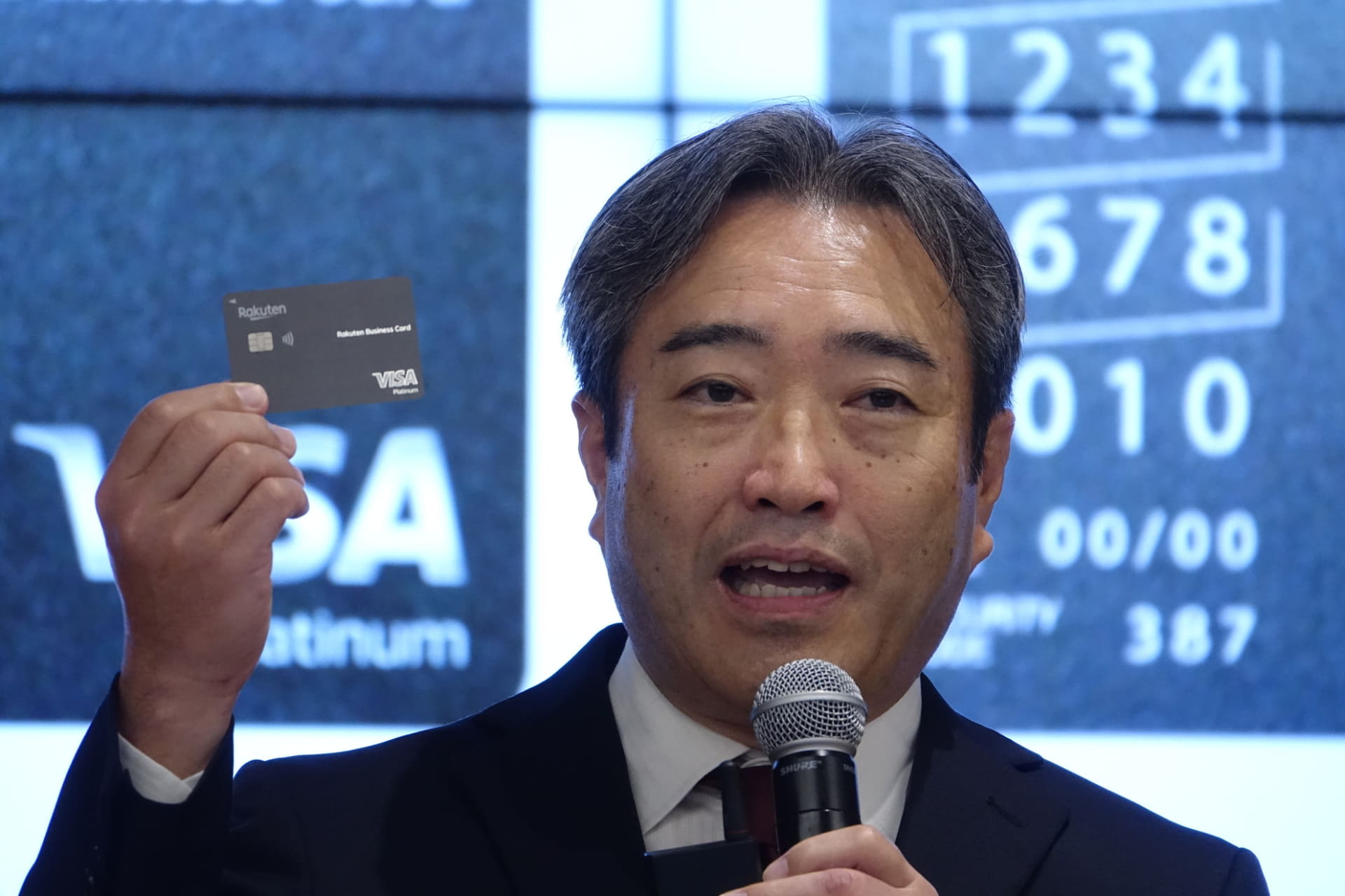「楽天ビジネスカードプラチナ」を掲げる楽天カード代表取締役社長の中村晃一氏