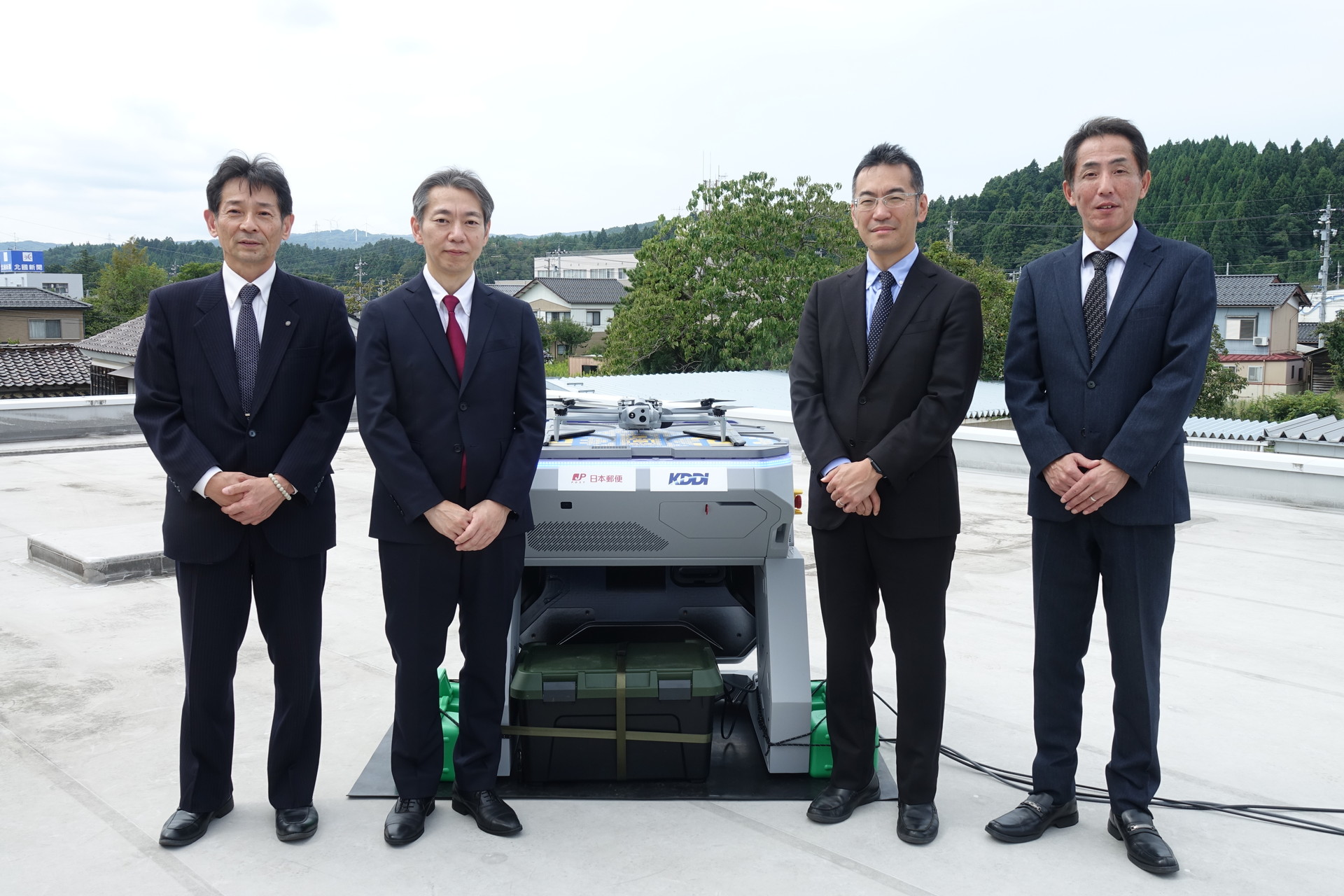 左から石川県能登地区連絡会 地区統括局長/町野郵便局長 坂口高雅氏、日本郵便 郵便・物流事業統括部 部長の三山正和氏、KDDIスマートドローン 代表取締役社長の博野雅文氏、珠洲郵便局長の中川勝博氏