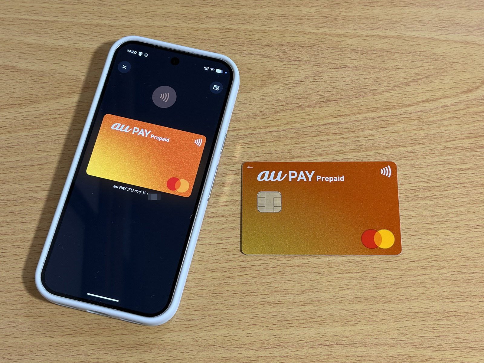 au PAY プリペイドカードのプラスチックカード（右）。スマホ画面に表示しているのが、Google Payに登録したバーチャルカードです