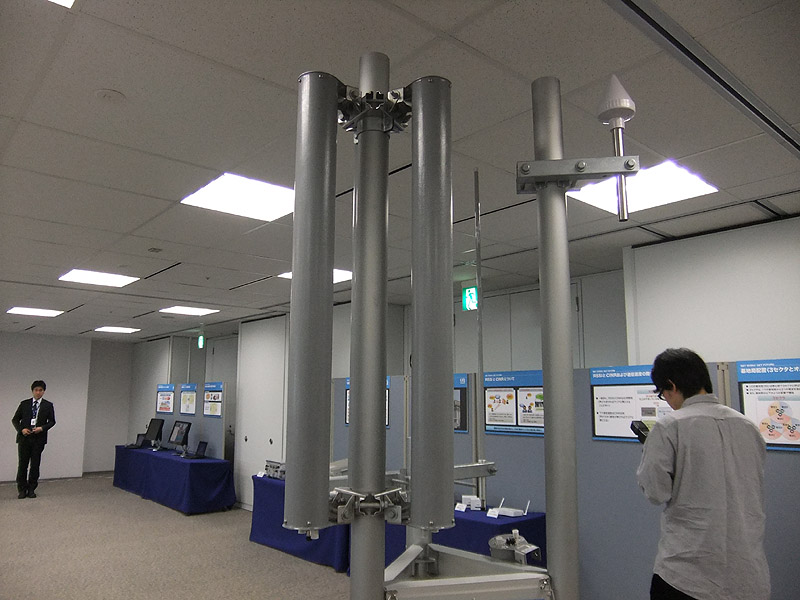 3セクタタイプの基地局アンテナ。120度×3つの指向性アンテナを採用、右側の三角形の装置はGPS