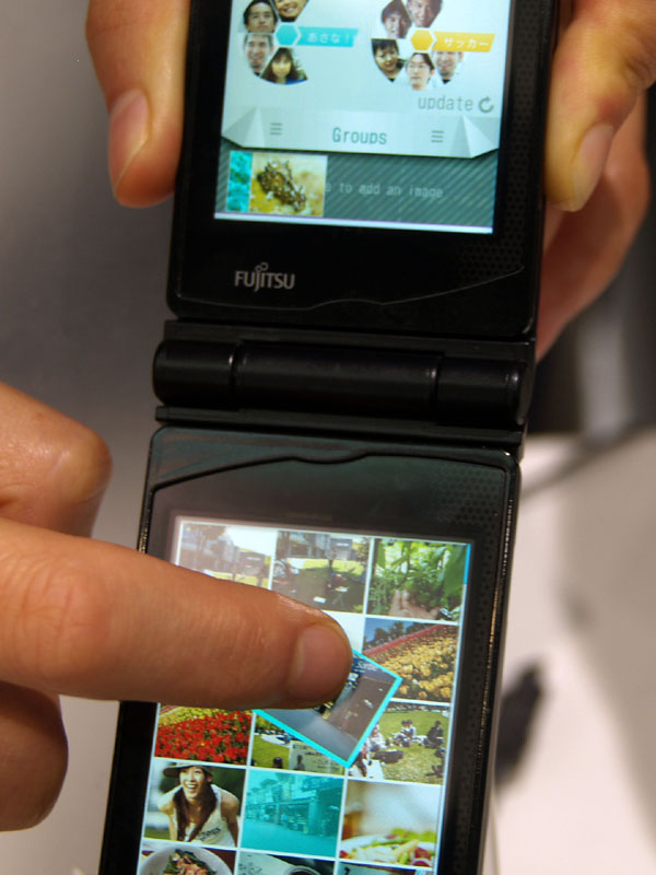 下画面で画像にタッチし、上に向かって弾くと画像が上画面に飛ばされる。グループを選択すればグループ内の全員で画像を共有できるというイメージ