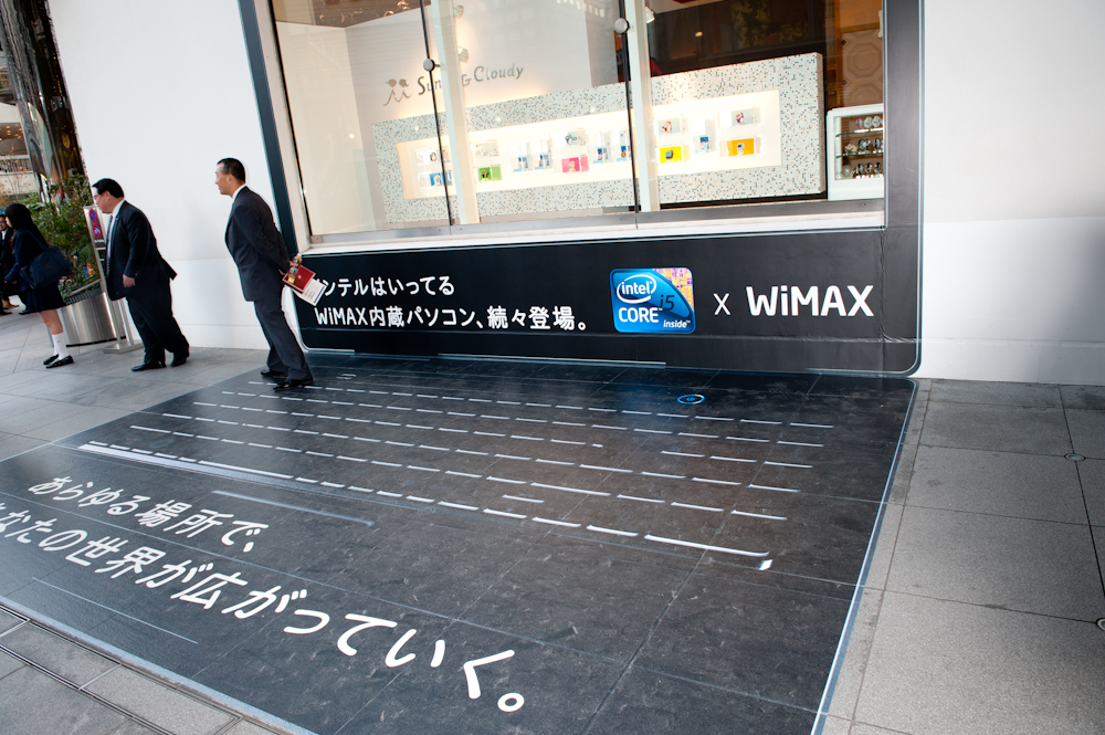 近くのビルの壁面と通路にはノートパソコンを模したラッピングの広告