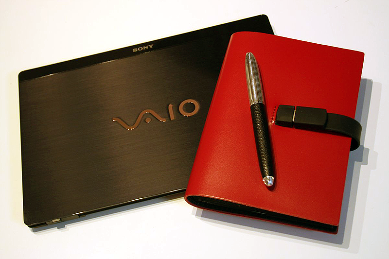 赤い革表紙のアナログメモが、クールでメタルなデジタルガジェットとマッチする