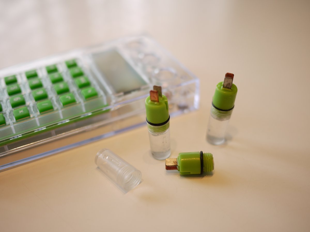 小さな水力電池のキャップを外して水道水を流し込む