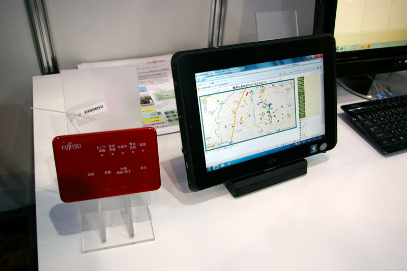 赤い端末が就労者が身につけるGPS端末