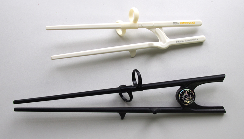 エジソンのお箸II（成人女性向け）と旧エジソンのお箸（成人男性向け）。現在成人男性向け（黒い方）は販売されておらず。もう少し短くなったエジソンのお箸IIIが販売されている