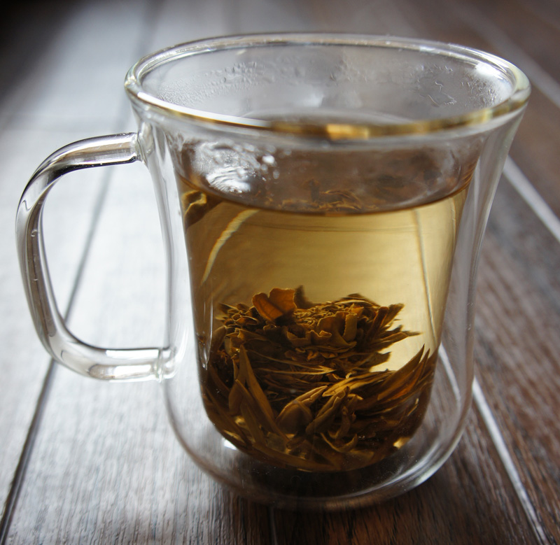 丸くまとめられた茶葉が広がるタイプのジャスミンティを入れた様子。これは全部茶葉なので今ひとつぱっとしない絵になってしまったが、工芸茶、花茶などと呼ばれる種類のお茶ならかなりきれいだと思う