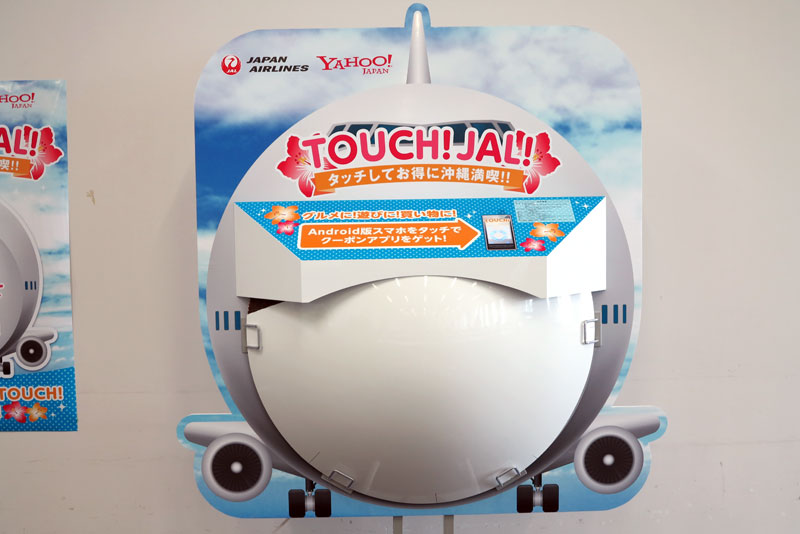 今夏、那覇空港に設置されたNFC対応ポスター。ジャンボジェットの先端部分が用いられ、子供の好奇心をくすぐり、スマホアプリをダウンロードさせて、実店舗を案内する仕組み
