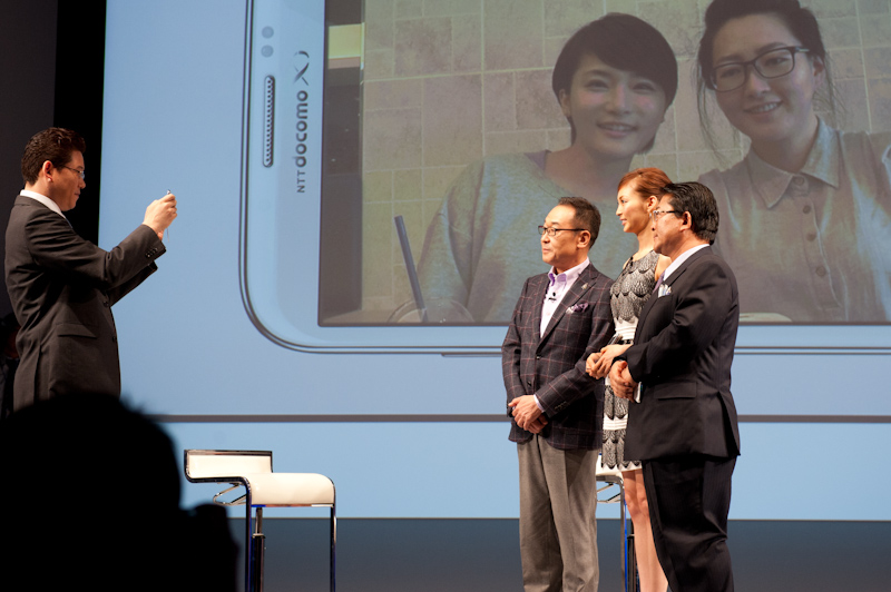 ステージ上の3人でベストフェイス機能を体験。左は司会を務めたアナウンサーの山中秀樹氏