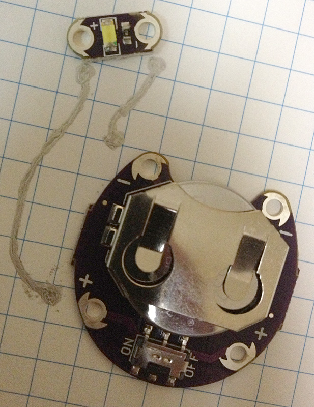 導電ペーストで回路を作成してみた。大きい基板には電池（CR2032）と電源スイッチが、小さい基板には白色LEDが搭載されており、基板の端子は裏面にもある