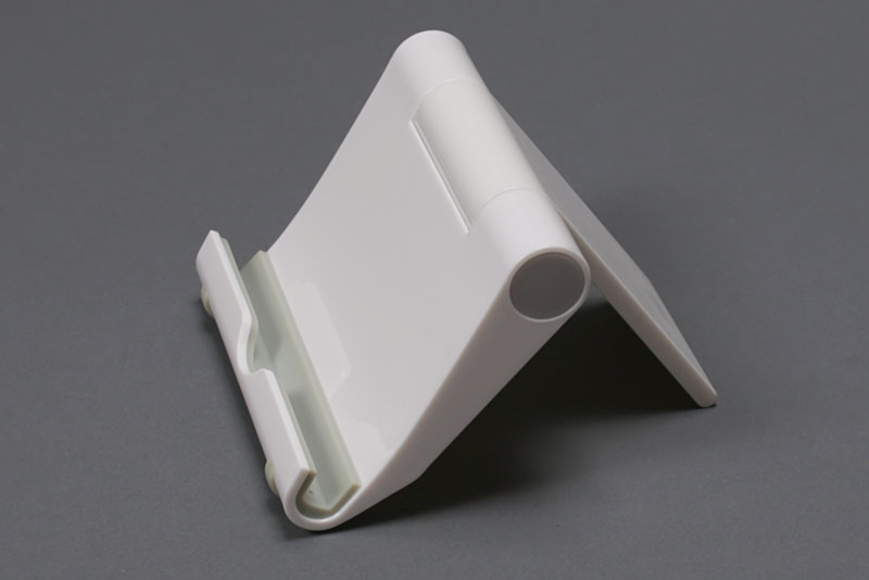 サンワサプライの「iPadスタンド（ホワイト） PDA-STN7W」。角度調節が可能スタンドで、iPad専用となっているがいろいろな端末に使えた。スタンドを閉じるとポケットサイズのコンパクトさになる。軽量なので常時携帯も現実的