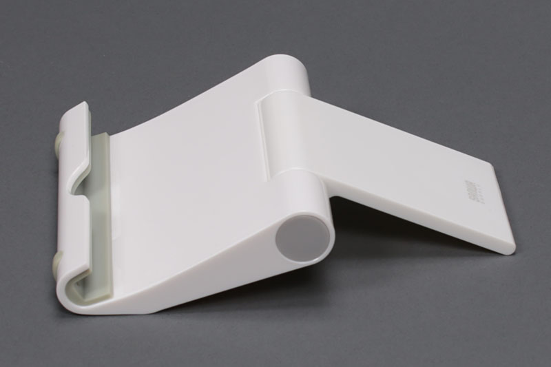 サンワサプライの「iPadスタンド（ホワイト） PDA-STN7W」。角度調節が可能スタンドで、iPad専用となっているがいろいろな端末に使えた。スタンドを閉じるとポケットサイズのコンパクトさになる。軽量なので常時携帯も現実的