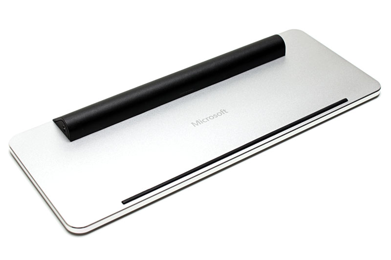 カバーは中央から折れ、自由な角度に固定でき、タブレットスタンドとして使える。キーボード裏面には電池室があり、キーボードの脚として機能する。電池は単4形×2本を使用。細く黒い線は滑り止め。キーボード裏面にもカバーにも新しい「Microsoft」ロゴがある