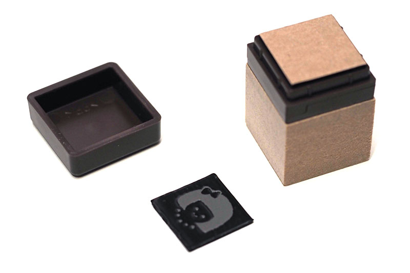 黒い部分がスタンプで、そのなかのグレーの部分が印影となる。シートを折ってスタンプ面を取り出し、スタンプベースに貼り付ける