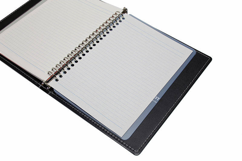 リング穴アダプターをノートに装着し続けるなら、リング穴アダプターの出っ張りで書きにくくなる問題を回避するための下敷きが必須となる。写真は自作の下敷き。A4サイズの「表紙もリングで綴じるタイプのバインダー」の樹脂表紙をA5サイズにカットしただけのものだが、けっこー実用的っす