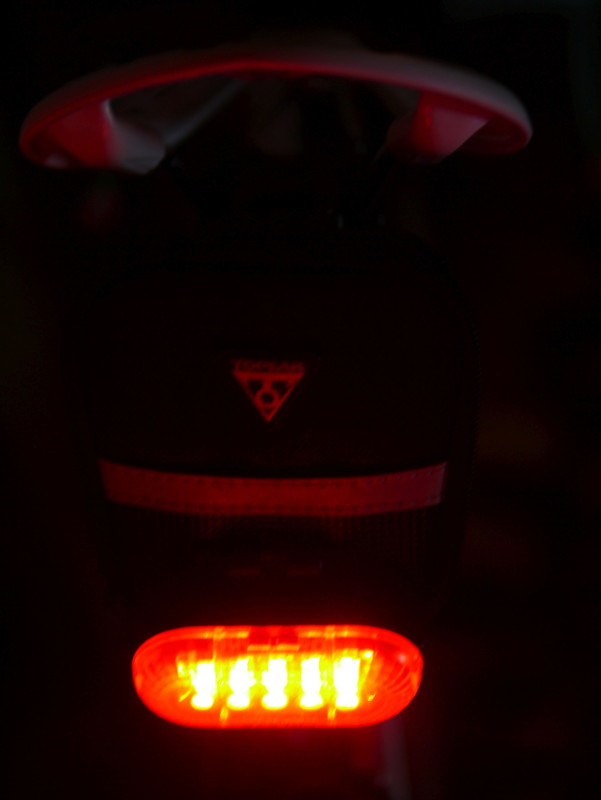 サドルバッグの下に着けた別のライト（左）と、Aero Wedge iGlowのライト（右の画像）。明るさ自体はそこまで変わらないが、発光面積が広い分Aero Wedge iGlowの方が目立って見える