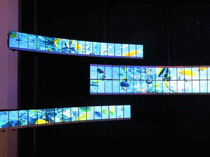 大量のAQUOS CRYSTALを円弧状に並べ、アニメーションを表示する展示。狭額縁スマホならでは