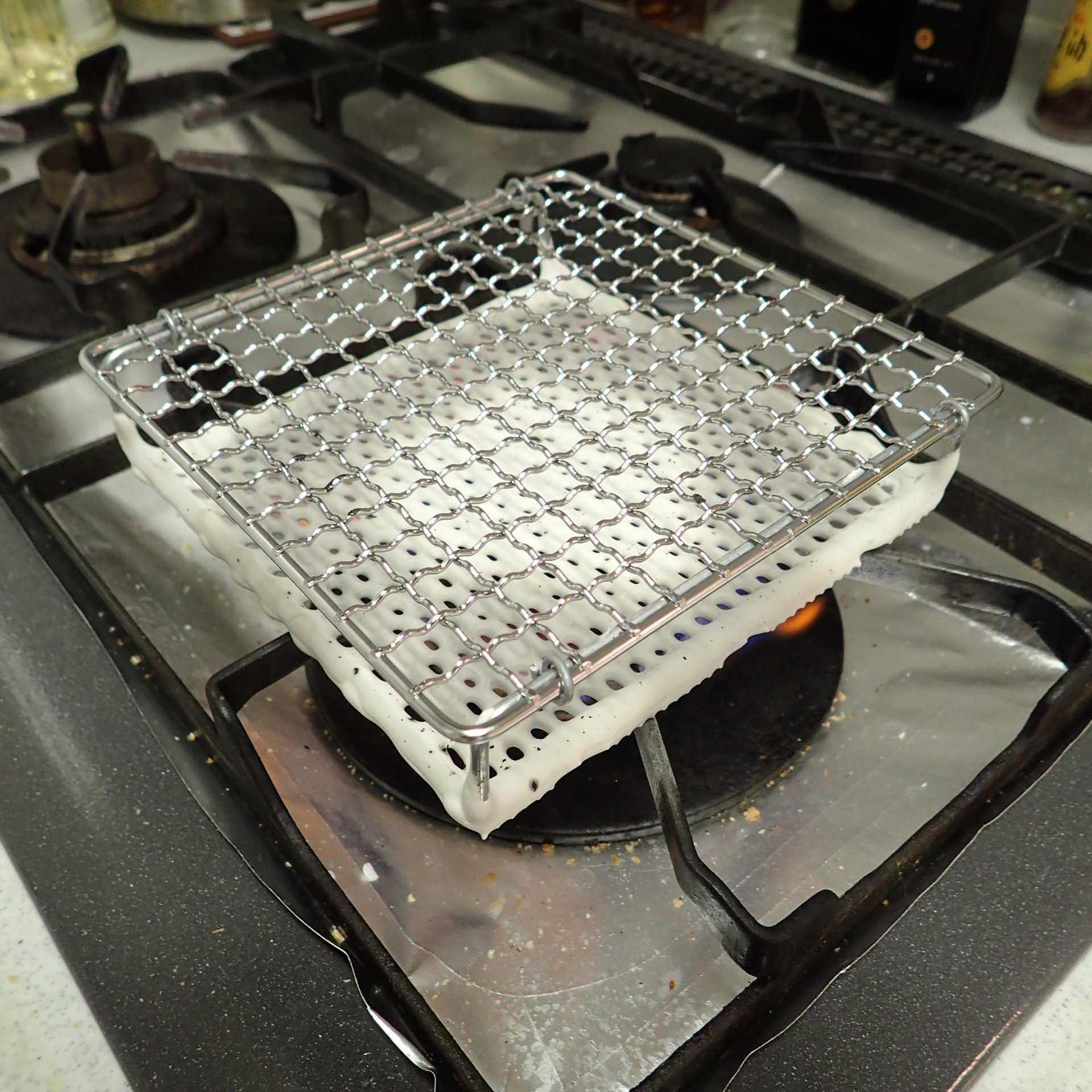 まずは1分ほど、ガスレンジの中央にセラミック焼網を置き、小さなガス火の空焼きでウォーミングアップ