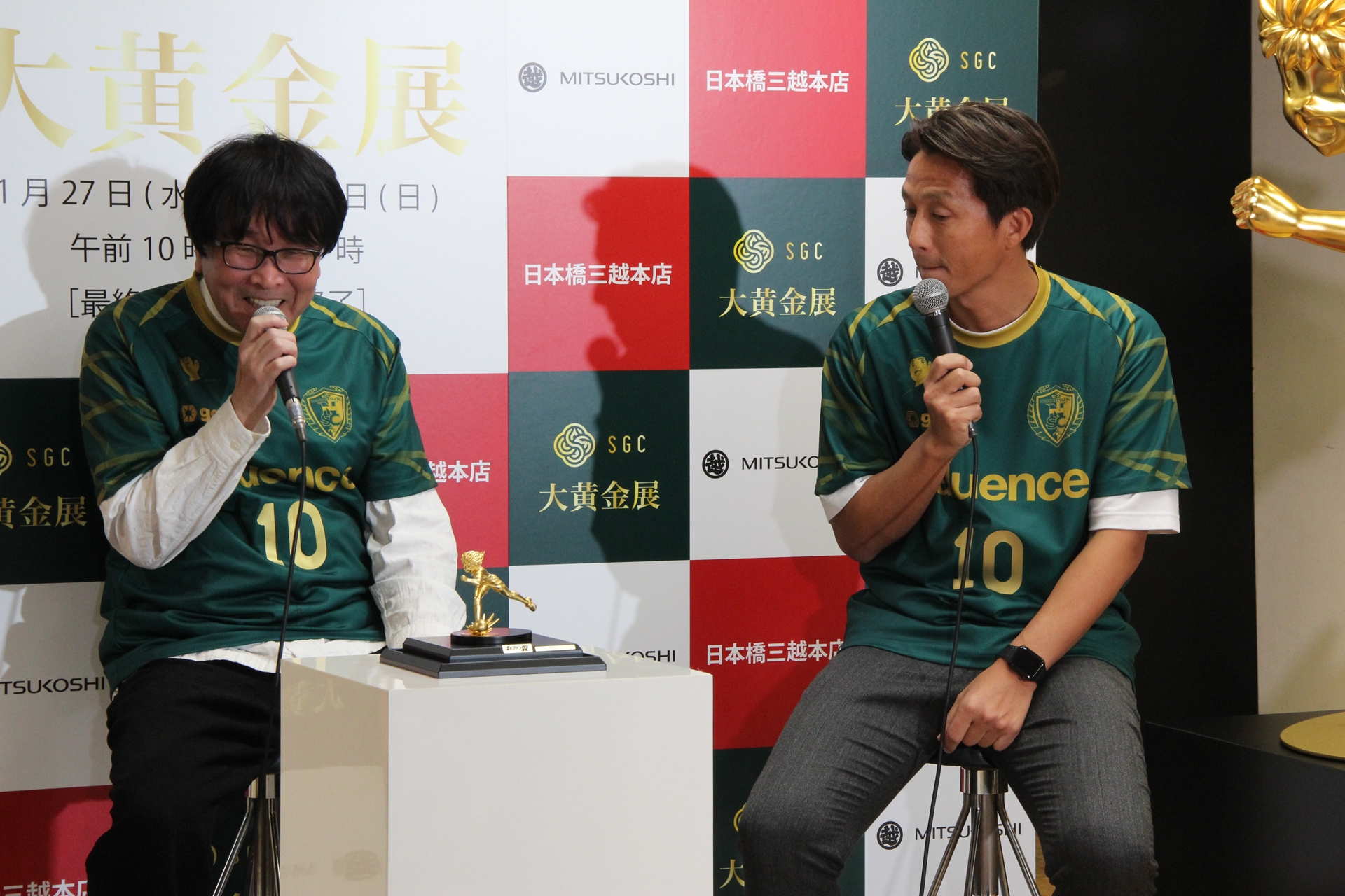 南葛SCのユニフォーム姿で登壇した福西氏。トークセッション中は高橋氏と一緒に、純金の大空翼像を眺めつつさまざまな話題について語ってくれた