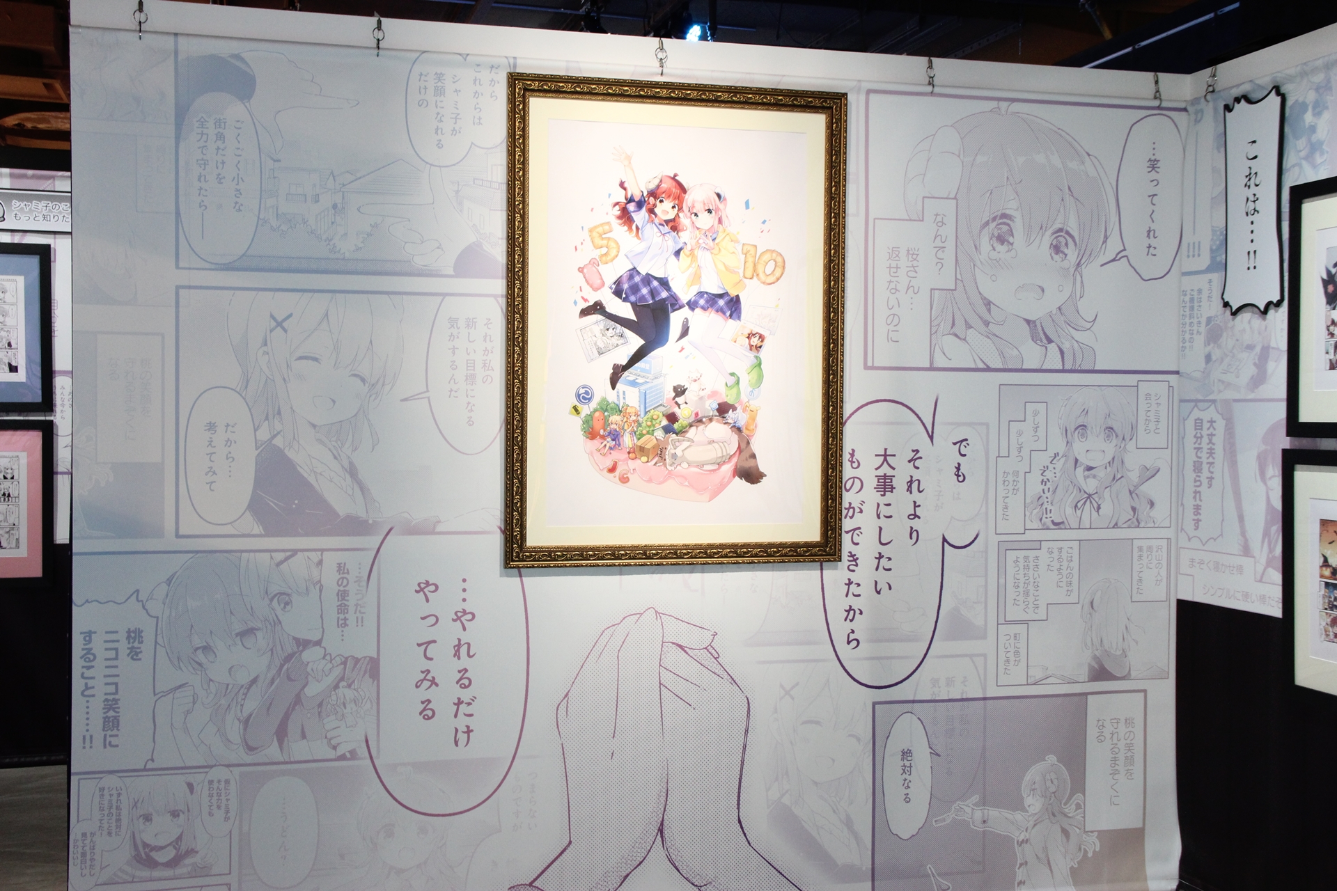 喫茶「あすら」エリアは、入ると目の前に「まちカドまぞく だぶるあにばーさりー展」描き下ろしイラストの複製原画が飾られている。その背景に使われているのは単行本3巻のクライマックスシーン。涙腺の弱い人は、ちょっと要注意かもしれない