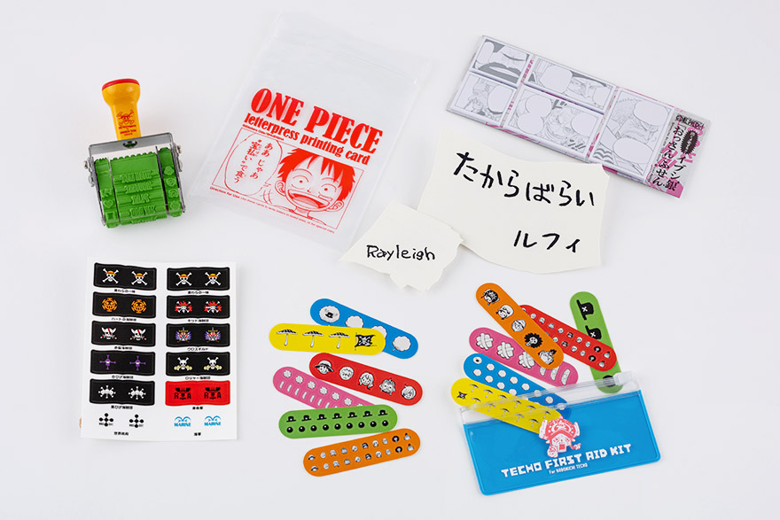 (左上から時計回りに) サンビー×ほぼ日 手帳と使う回転印 ONE PIECE / ビブルカード＆たからばらいの活版印刷カード / イブシ銀「おっさん」ふせん / チョッパーの手帳救急シール / 海賊旗 インデックスシール