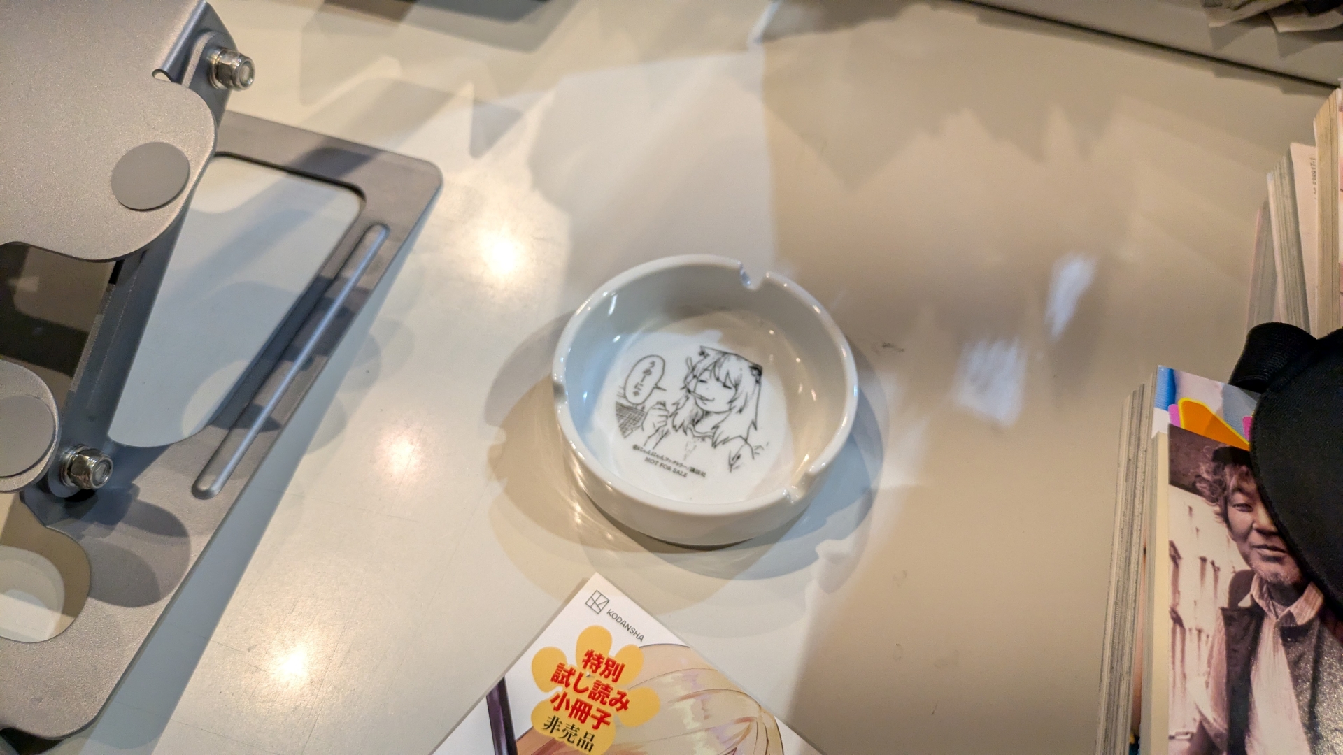 ヤンマガ編集部員のデスクを再現した「ヤンマガ編集部転生ブース」。講談社の校正ハンドブックが置いてあるかと思えば「ヤニねこ」印の灰皿もあったりする