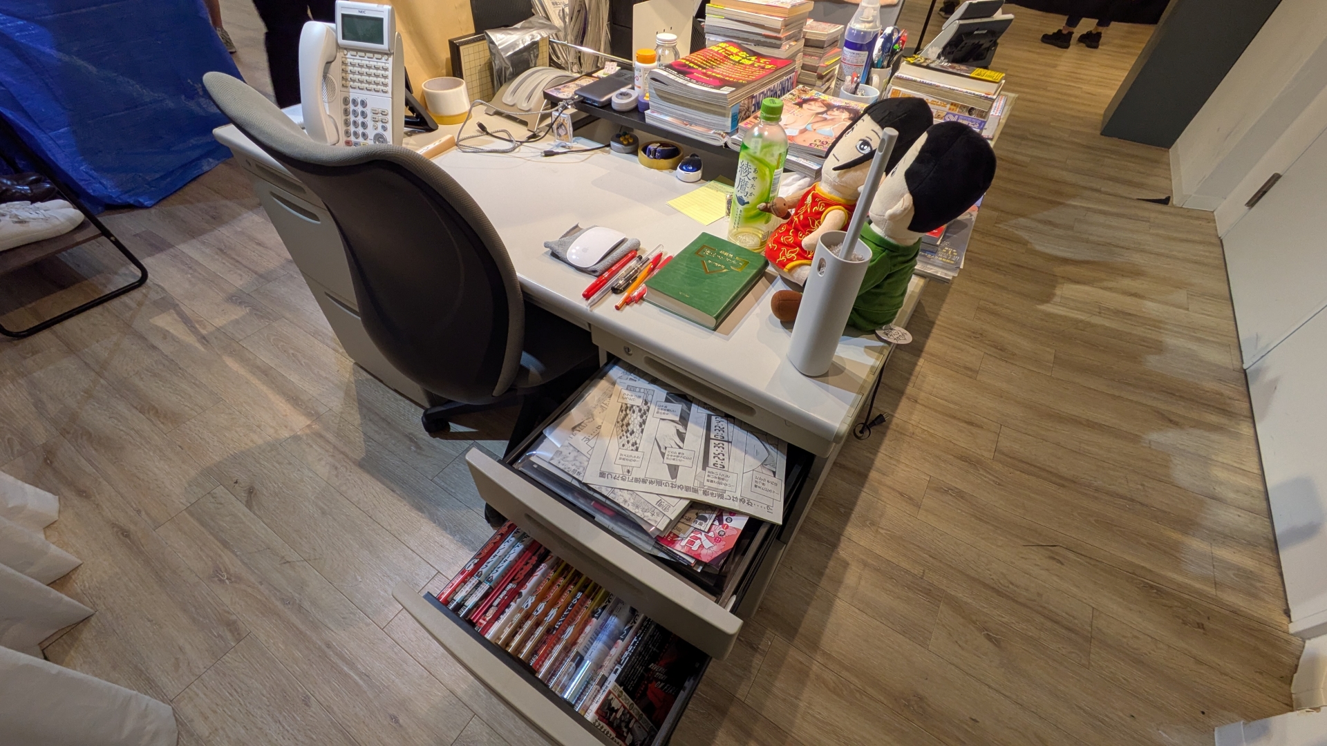 ヤンマガ編集部員のデスクを再現した「ヤンマガ編集部転生ブース」。講談社の校正ハンドブックが置いてあるかと思えば「ヤニねこ」印の灰皿もあったりする