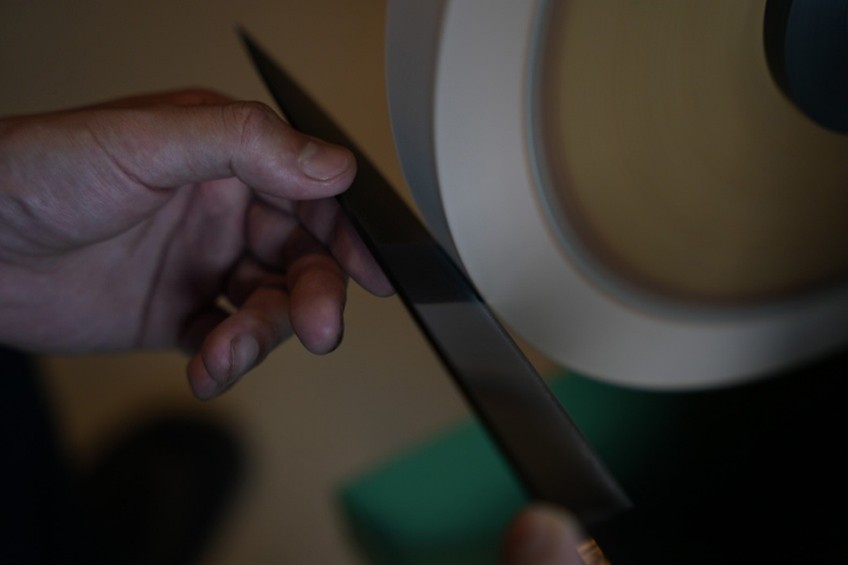 包丁の命である刃付けの工程は機械ではなく、熟練の職人の手によって行なわれている