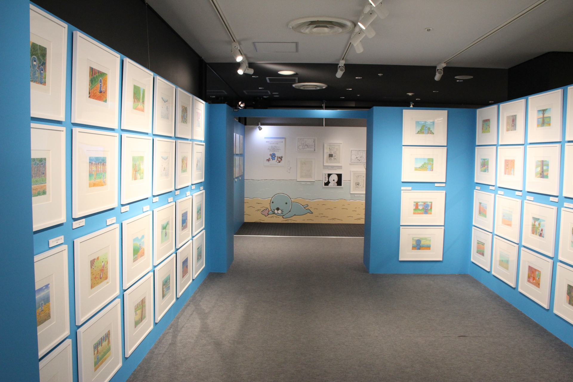 最初に目にすることになる展示物は、コミックスの表紙と裏表紙の原画イラスト。50冊分がズラリと並んでおり、迫力に思わず圧倒される