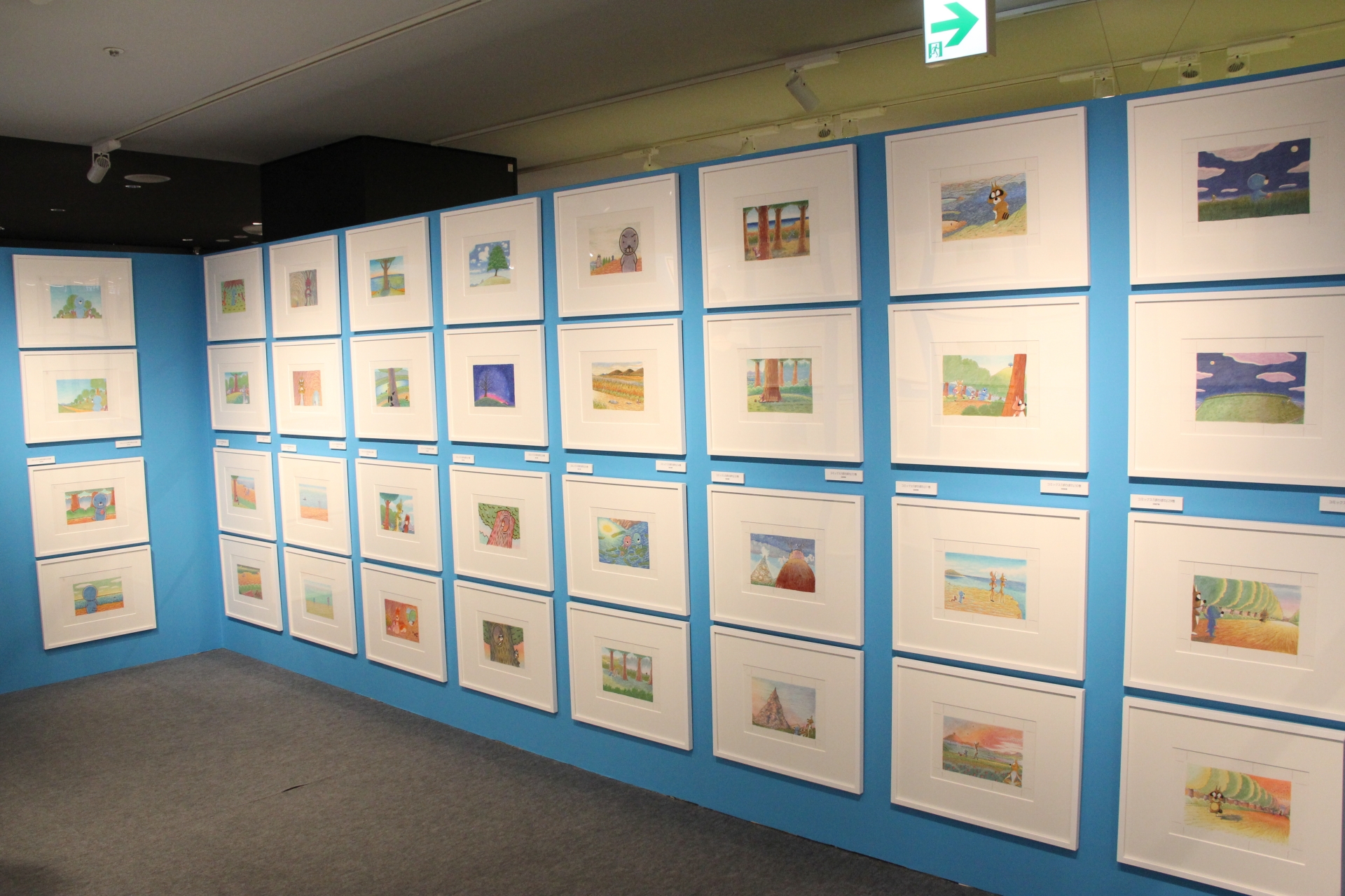 最初に目にすることになる展示物は、コミックスの表紙と裏表紙の原画イラスト。50冊分がズラリと並んでおり、迫力に思わず圧倒される