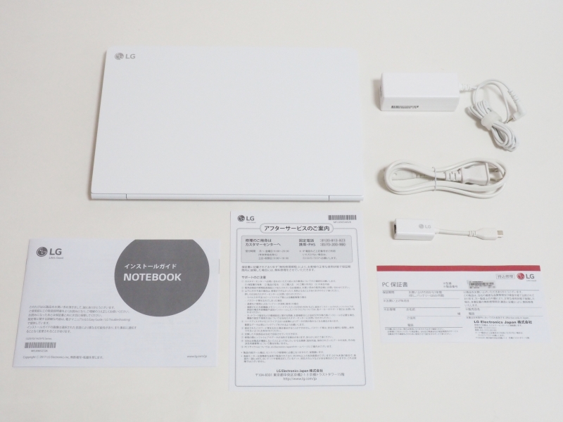 同梱品一覧。左上から本体、ACアダプタ、電源ケーブル、有線LANアダプタ、小冊子(インストールガイド、アフターサービスのご案内、保証書)