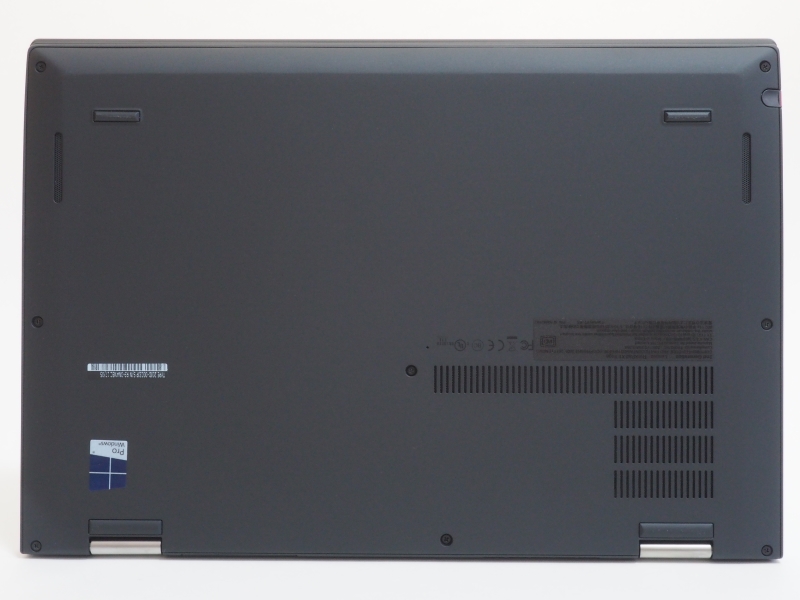 本体底面。上部両側面にスピーカー、右下にファン放熱口、中央のネジ右上に緊急用リセットホールが設けられている