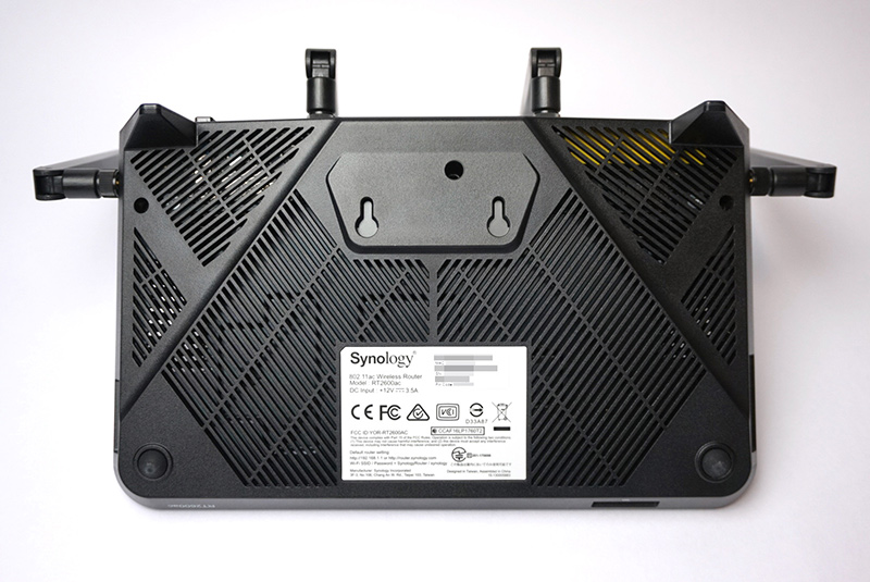 底面。壁掛け用の穴とMACアドレスやシリアル、PINコードが印刷されたシールがある