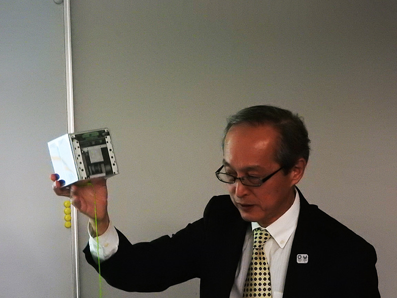 青木教授が手にしているのが、超小型テザー衛星のイメージモックアップである