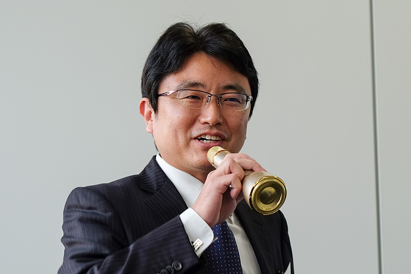 ゴッパ合同会社 九鬼隆則氏。手に持つマイクは同社のBluetooth接続できるスピーカーを内蔵する<a href="https://av.watch.impress.co.jp/docs/news/1077263.html">カラオケマイク</a>